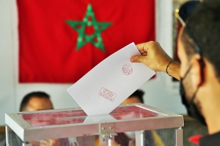 Un électeur plaçant son bulletin de vote dans une urne lors des élections de 2021.