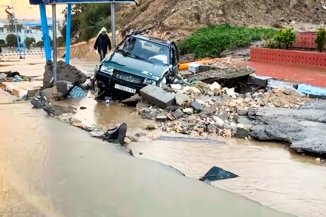 Une voiture bloquée dans les débris d'une chaussée endommagée par les inondations survenues à Safi, le 14 décembre 2025