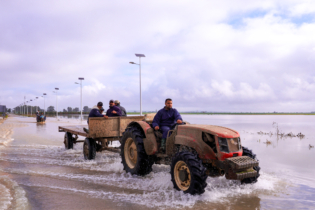Un agriculteur circulant au volant de son tracteur sur une route inondée dans la commune d’El Houafate, relevant de la province de Sidi Kacem.