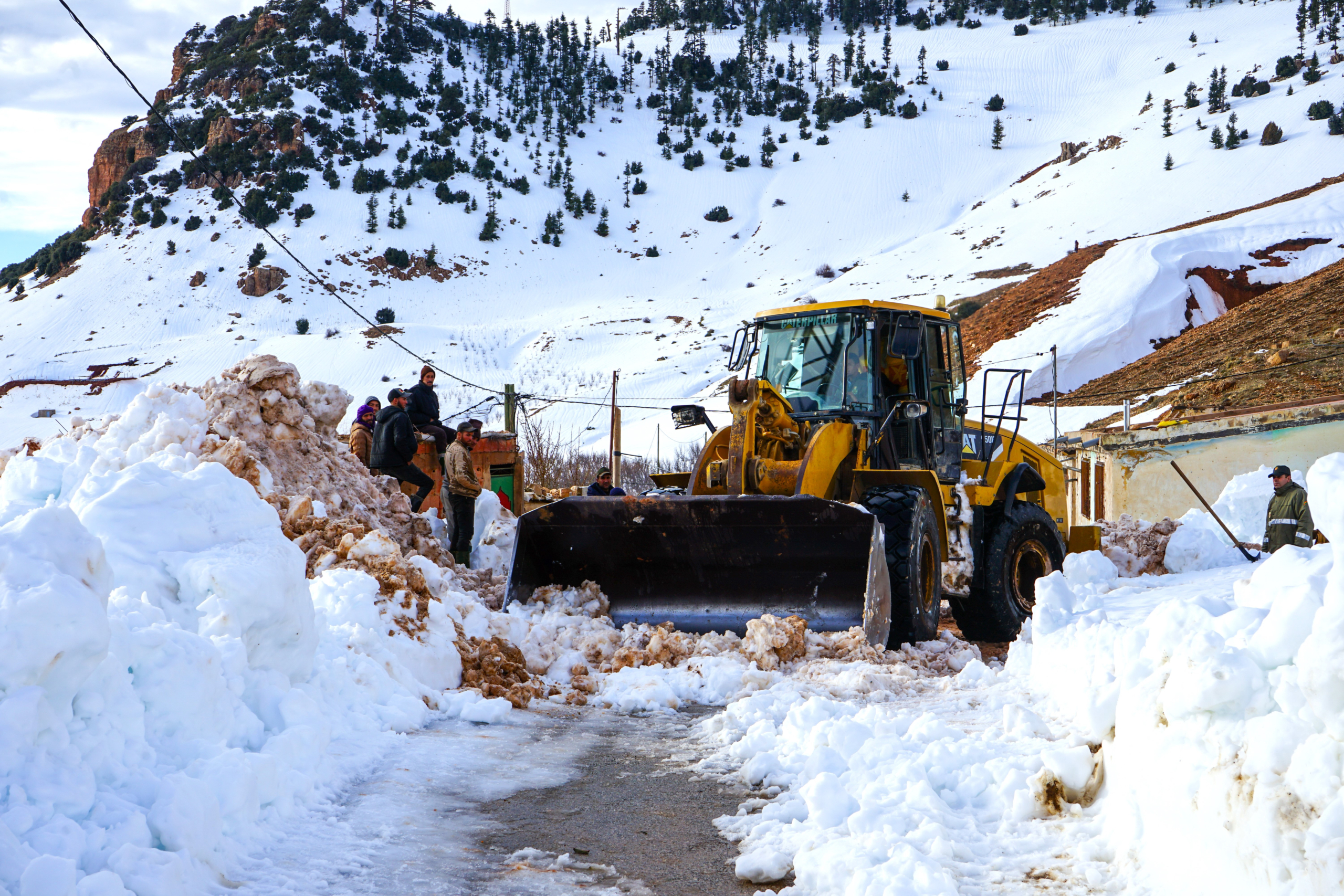 Une pelleteuse dégageant une route de montagne dans la province de Midelt. Crédit : MAP