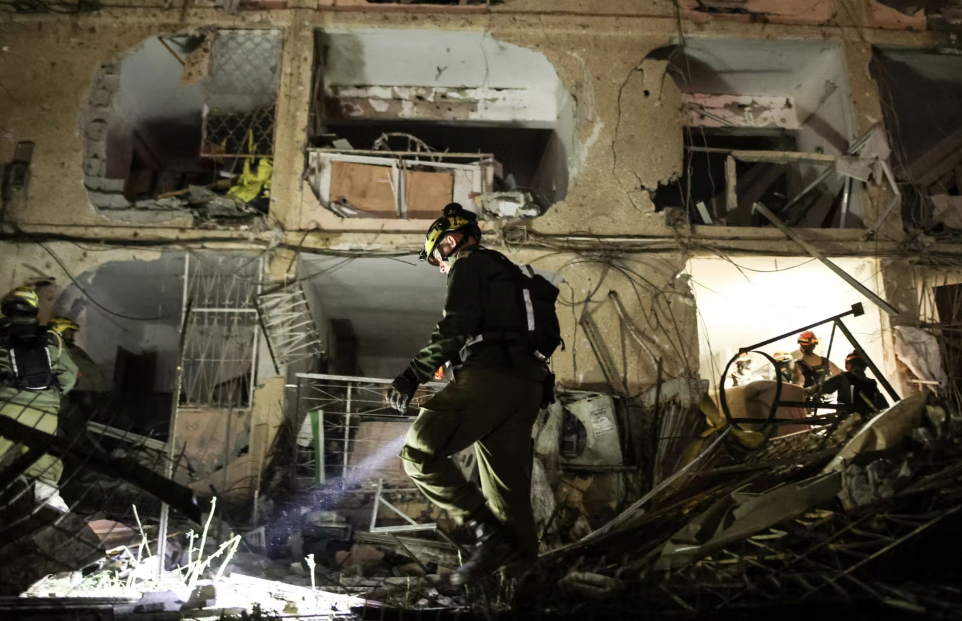 Un soldat israélien inspecte les dégâts causés par les salves de missiles iraniens qui ont frappé Dimona, dans le sud d’Israël, le 21 mars 2026