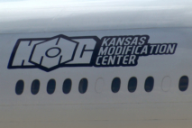 Un fuselage d'avion portant le logo de Kansas Modification Center (KMC), entreprise américaine spécialisée dans la conversion d'avions de passagers en avions cargo.