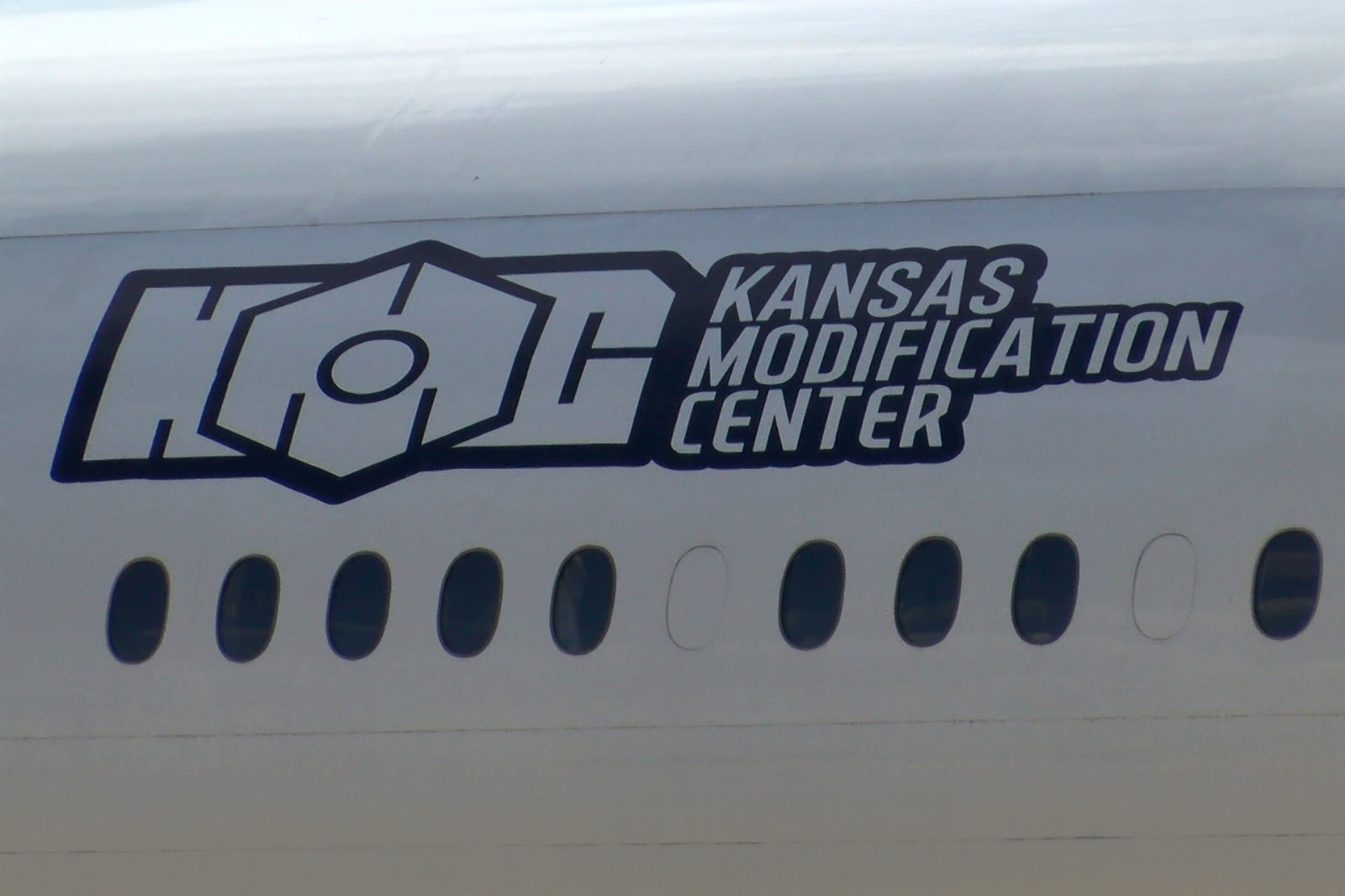 Un fuselage d'avion portant le logo de Kansas Modification Center (KMC), entreprise américaine spécialisée dans la conversion d'avions de passagers en avions cargo.