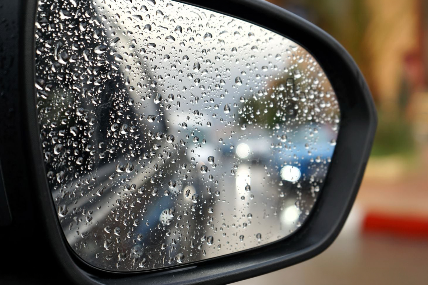 Une artère de Casablanca sous pluie, reflétée dans un rétroviseur.